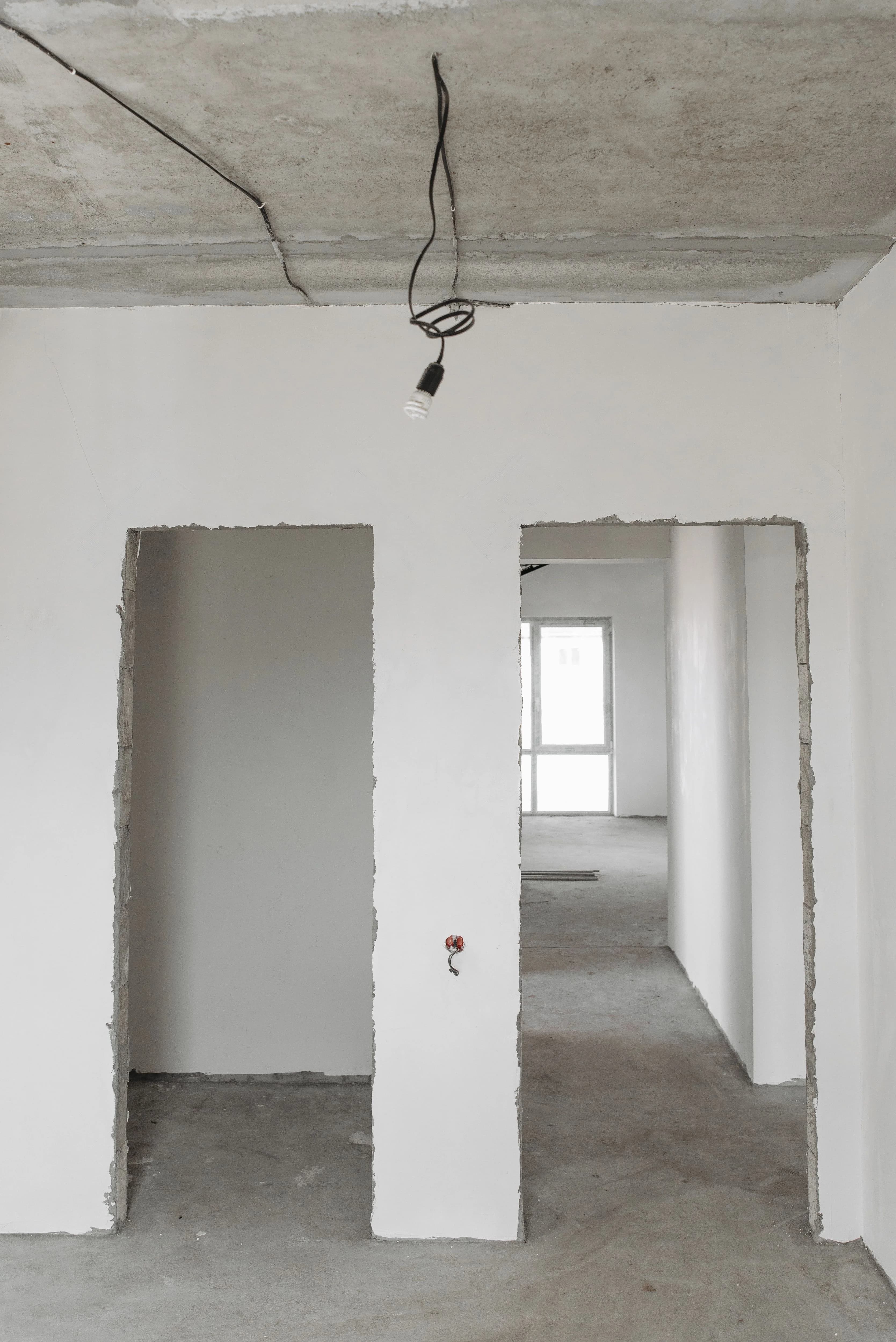 Logement récent en cours de travaux, plafond béton et réseaux apparents