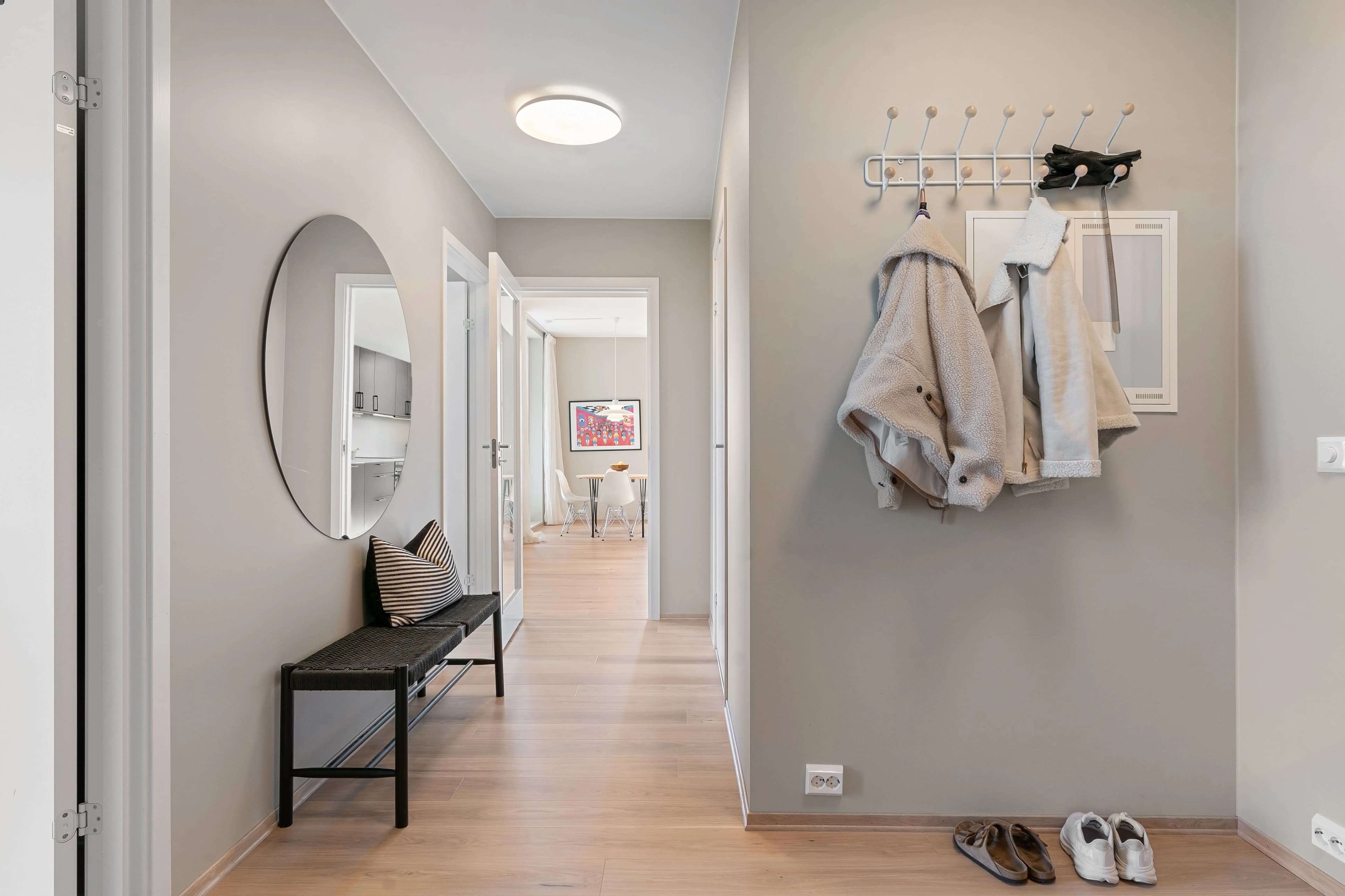 Entrée d'appartement avec banc, miroir et patères